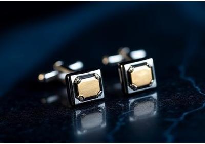 Close-up of exquisite geometric cufflinks crafted from polished sterling silver with onyx inlay.